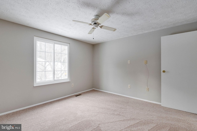 empty room with ceiling fan, carpet floors, and a textured ceiling