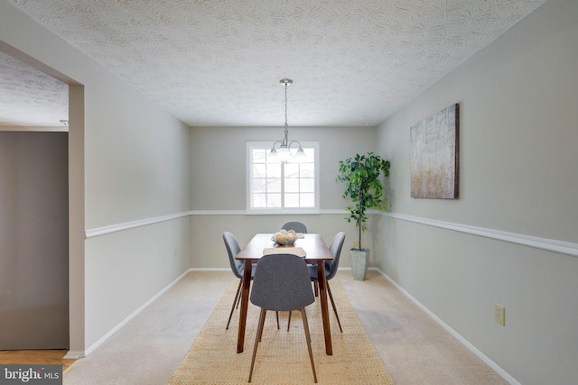 carpeted dining area featuring a textured ceiling