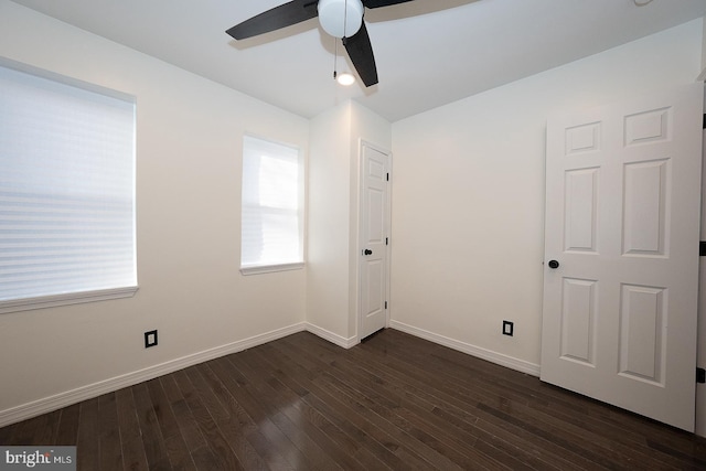 spare room with dark hardwood / wood-style floors and ceiling fan