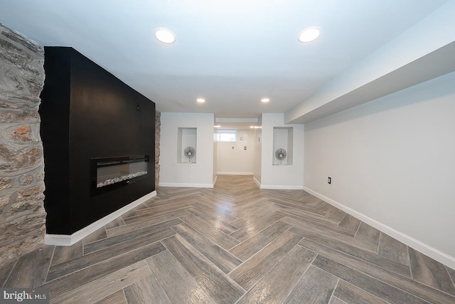 interior space with a large fireplace and parquet flooring