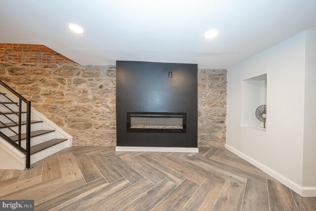 interior details featuring a fireplace and parquet flooring