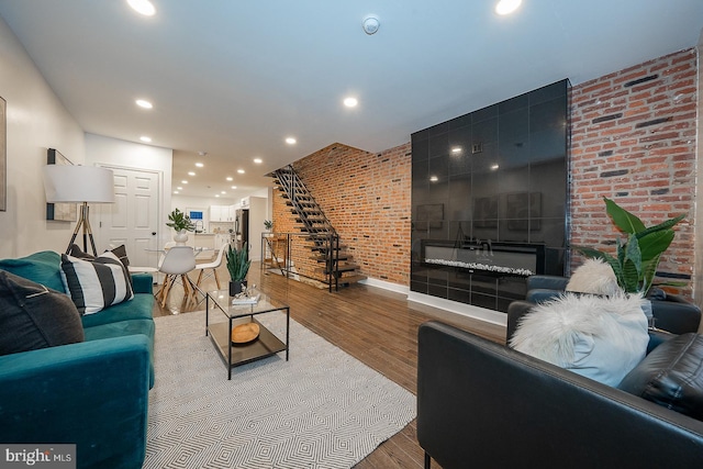 living room with wood-type flooring and brick wall