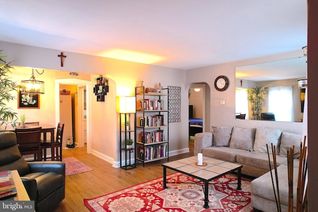 living room featuring wood-type flooring and an inviting chandelier