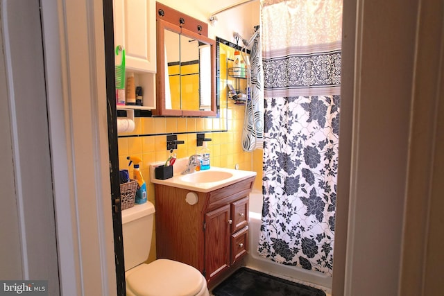 bathroom featuring curtained shower, tasteful backsplash, toilet, vanity, and tile walls