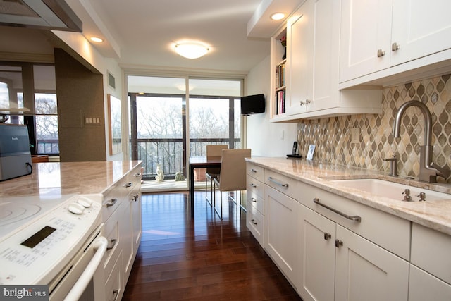 kitchen with light stone countertops, sink, dark hardwood / wood-style floors, white range with electric cooktop, and white cabinets