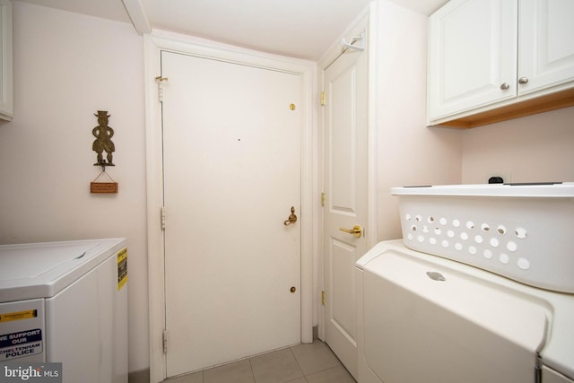 washroom featuring cabinets, light tile patterned floors, and separate washer and dryer