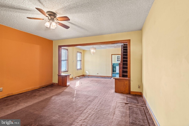 unfurnished room featuring a textured ceiling, ceiling fan, and carpet