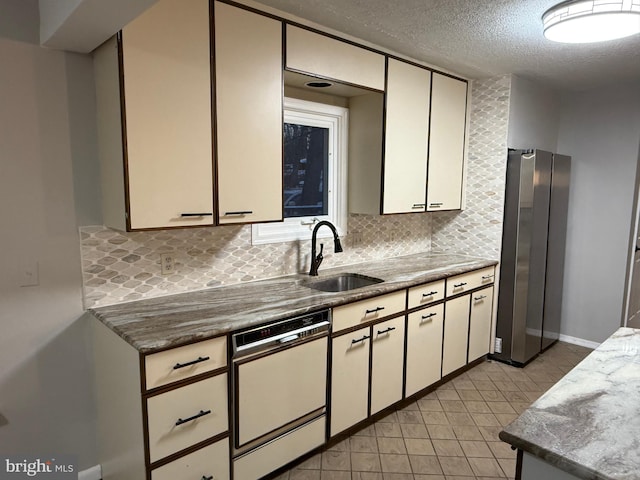 kitchen featuring stainless steel fridge, tasteful backsplash, a textured ceiling, sink, and dishwasher