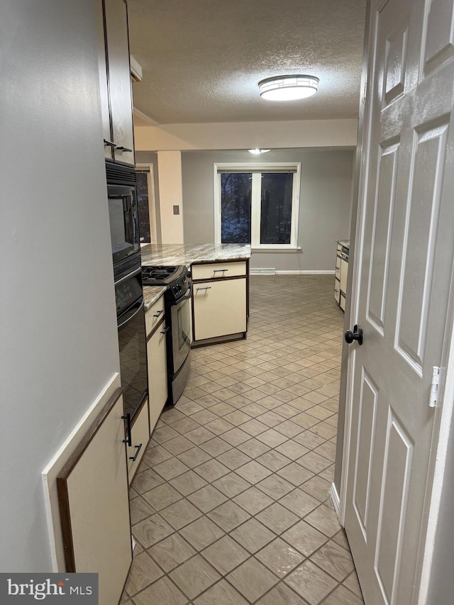 kitchen with black appliances and a textured ceiling