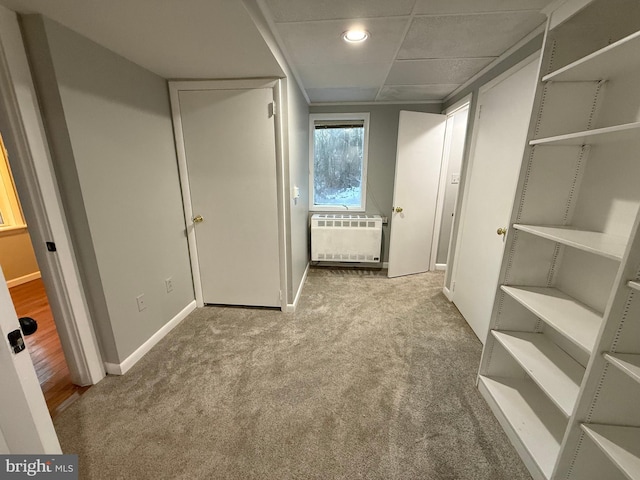 hallway featuring radiator heating unit and light carpet