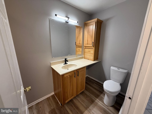 bathroom featuring hardwood / wood-style flooring, vanity, and toilet