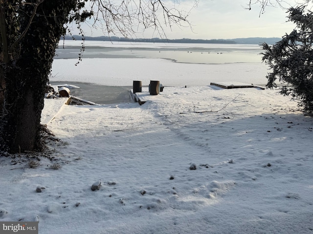 yard covered in snow with a water view