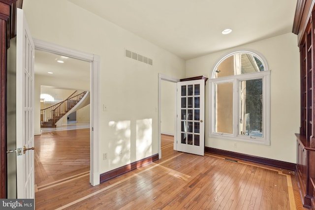 unfurnished room with french doors and light hardwood / wood-style floors