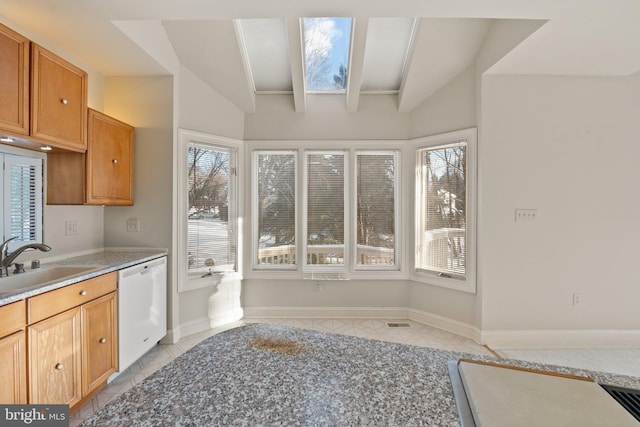 kitchen featuring light tile patterned floors, white dishwasher, lofted ceiling with skylight, and sink