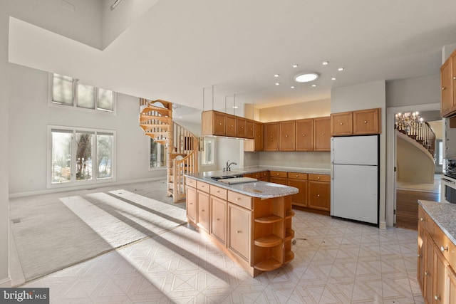 kitchen featuring sink, an inviting chandelier, wall oven, light stone counters, and white refrigerator