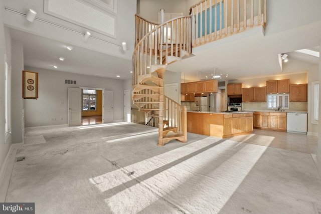 living room with a healthy amount of sunlight, a towering ceiling, and sink