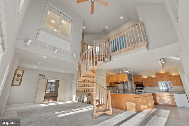 kitchen featuring ceiling fan, sink, a high ceiling, white appliances, and a kitchen island