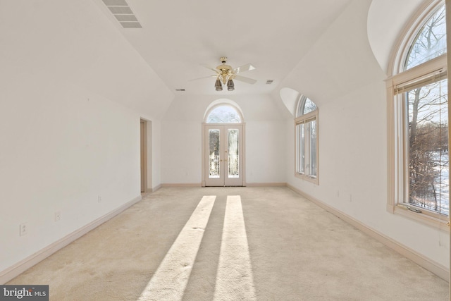 unfurnished living room featuring ceiling fan, a healthy amount of sunlight, and light carpet