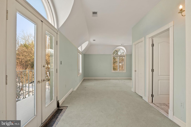 interior space with light carpet, vaulted ceiling, and a wealth of natural light