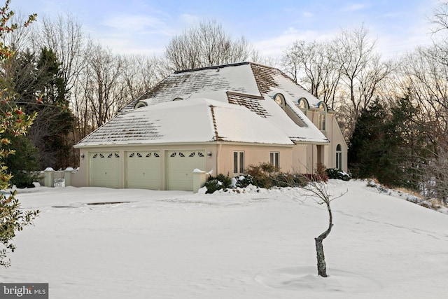 view of snowy exterior with a garage