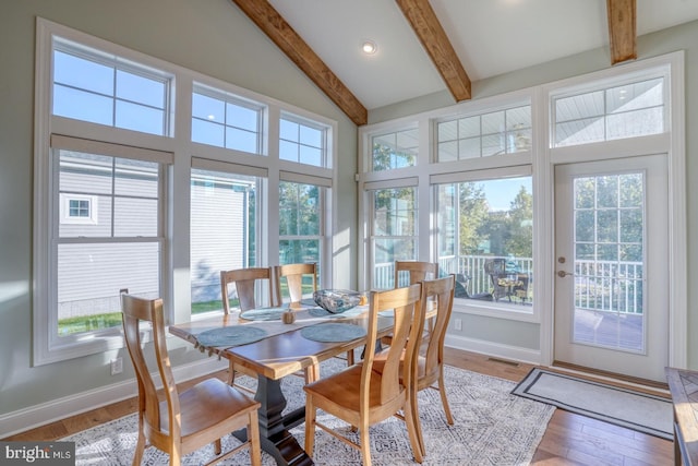 sunroom featuring vaulted ceiling with beams