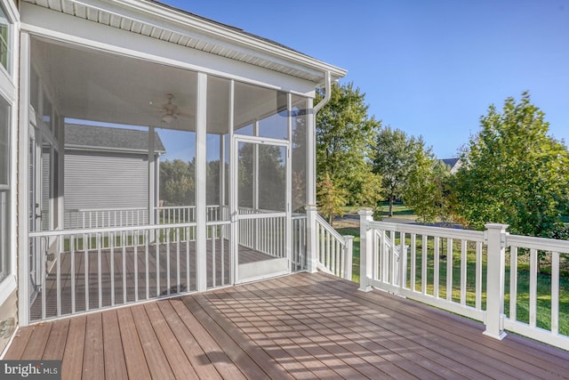 wooden terrace featuring ceiling fan and a sunroom