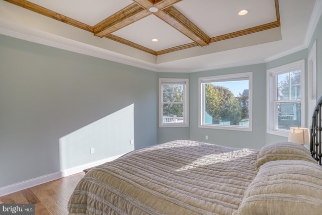 bedroom featuring crown molding, light hardwood / wood-style floors, coffered ceiling, and multiple windows