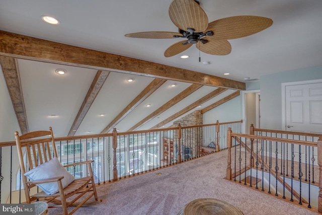 interior space with ceiling fan, carpet, and lofted ceiling with beams