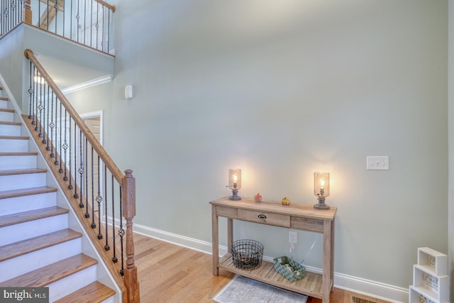 staircase featuring hardwood / wood-style floors and crown molding