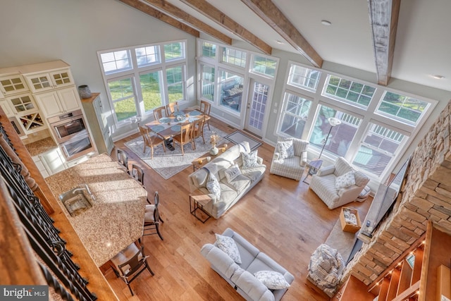 sunroom / solarium with sink, plenty of natural light, and beamed ceiling