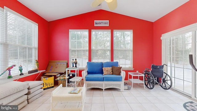 living area featuring lofted ceiling, light tile patterned floors, and ceiling fan