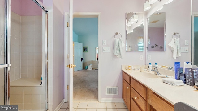 bathroom featuring tile patterned flooring, vanity, and walk in shower