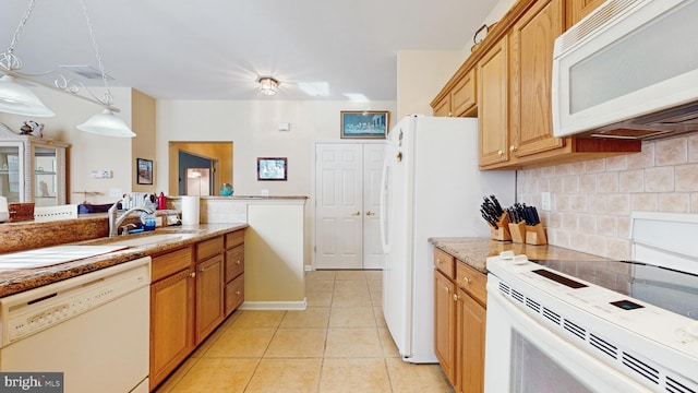 kitchen featuring sink, white appliances, light tile patterned floors, hanging light fixtures, and decorative backsplash