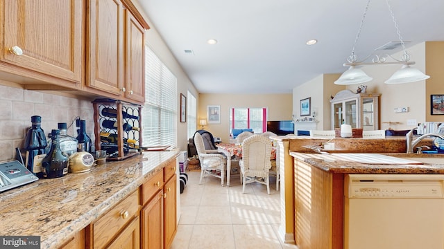 kitchen featuring light tile patterned floors, white dishwasher, light stone countertops, decorative backsplash, and decorative light fixtures