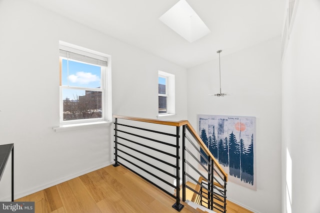 stairs with a skylight and hardwood / wood-style floors