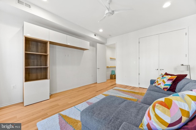 living room with light wood-type flooring and ceiling fan