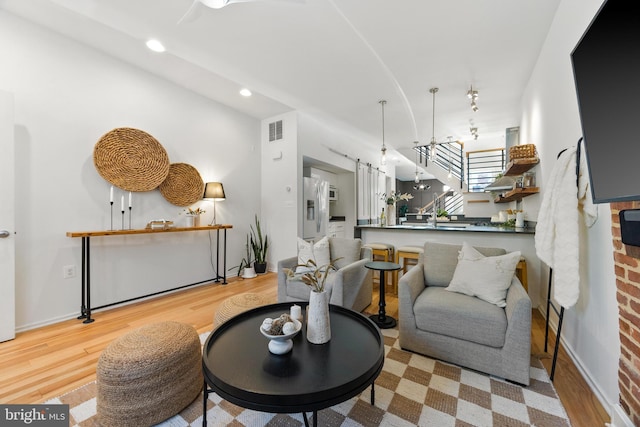 living room featuring lofted ceiling and light hardwood / wood-style flooring