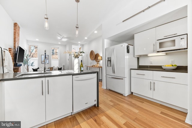 kitchen with white appliances, hanging light fixtures, light wood-type flooring, ceiling fan, and white cabinets