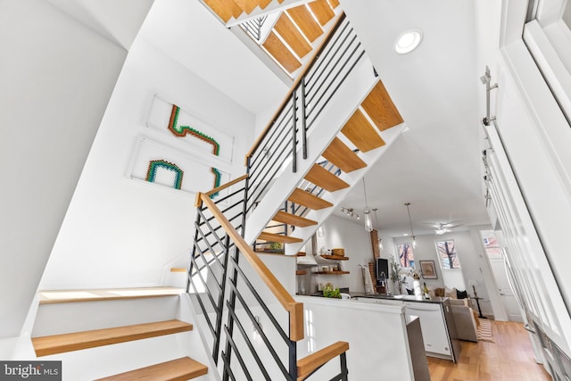 stairs featuring a towering ceiling and hardwood / wood-style floors