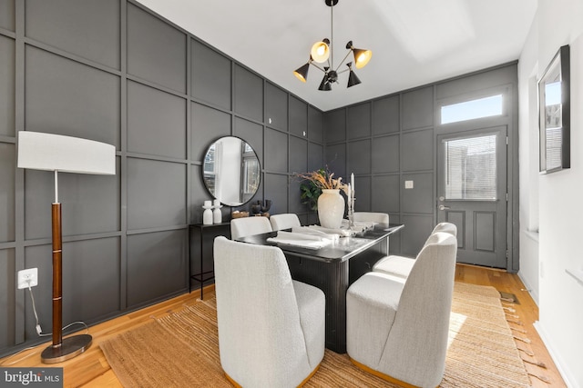 dining space with an inviting chandelier and light hardwood / wood-style floors