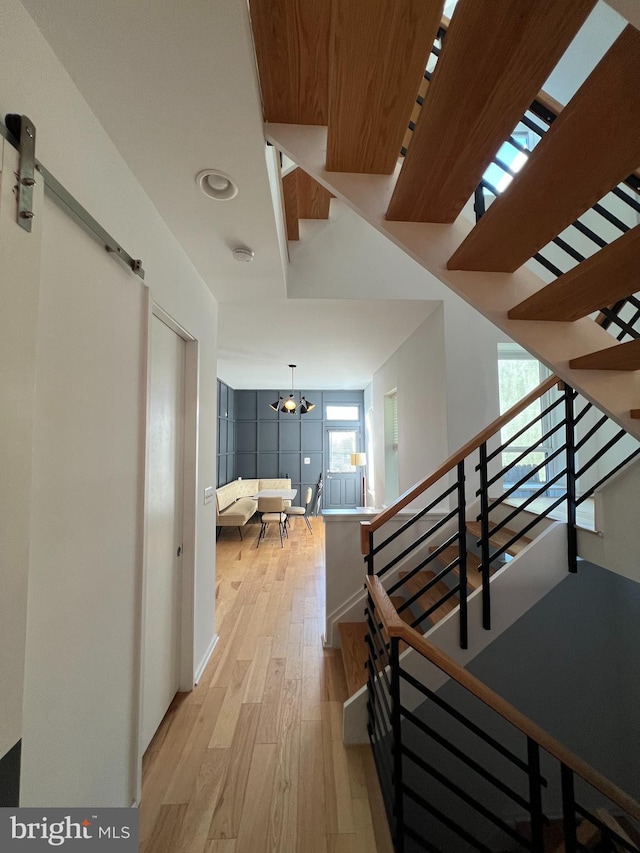 hall with a notable chandelier and light hardwood / wood-style flooring