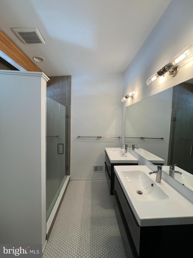 bathroom featuring a shower with door and vanity