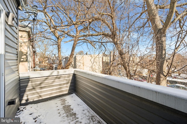 view of snow covered back of property