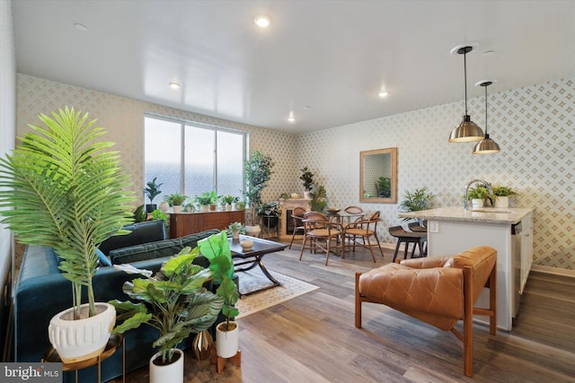 living room featuring hardwood / wood-style floors, a water view, and sink