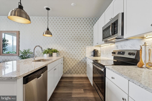 kitchen with white cabinetry, sink, decorative light fixtures, decorative backsplash, and appliances with stainless steel finishes