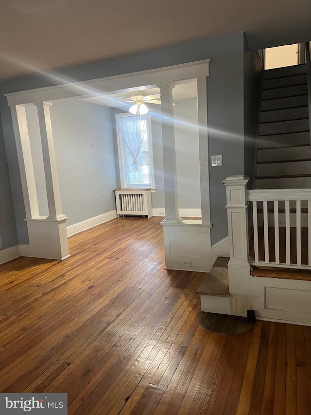 empty room featuring radiator, ceiling fan, and hardwood / wood-style flooring