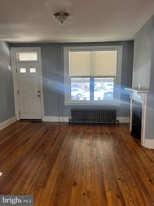 foyer entrance featuring radiator heating unit and dark hardwood / wood-style floors