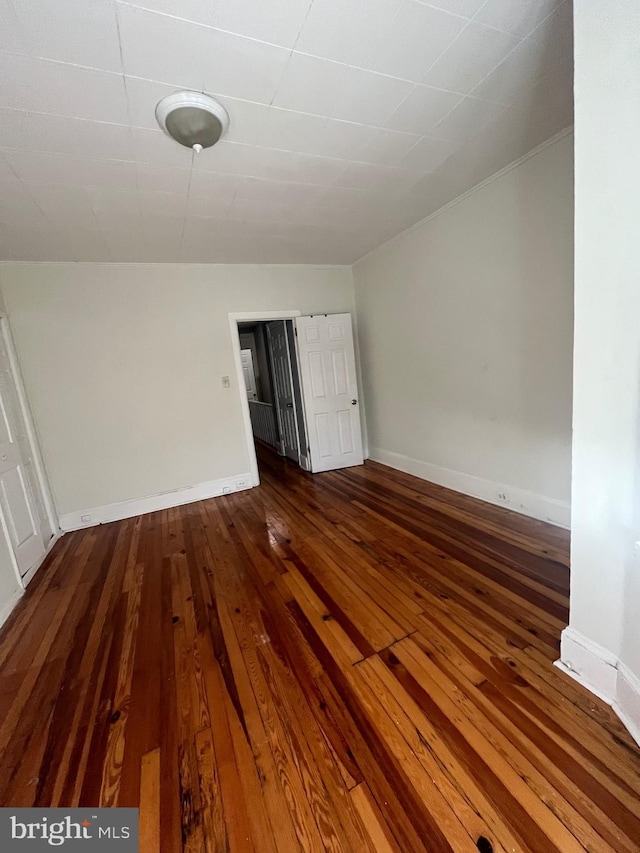 unfurnished room with dark wood-type flooring