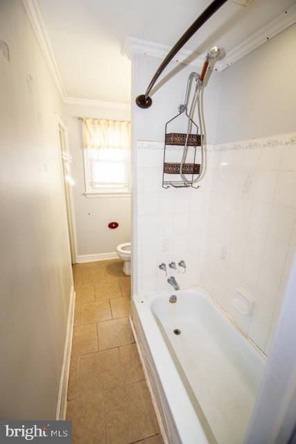 bathroom with toilet, tile patterned floors, shower / tub combination, and ornamental molding