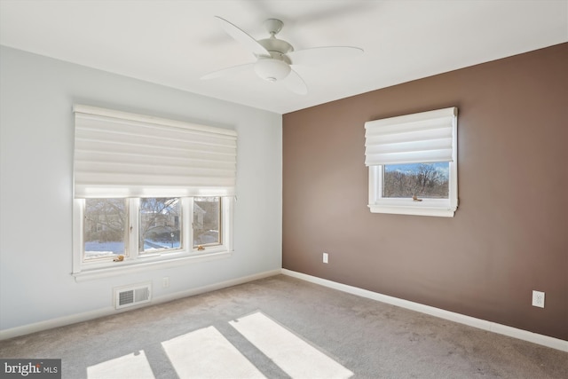 spare room with ceiling fan and light colored carpet